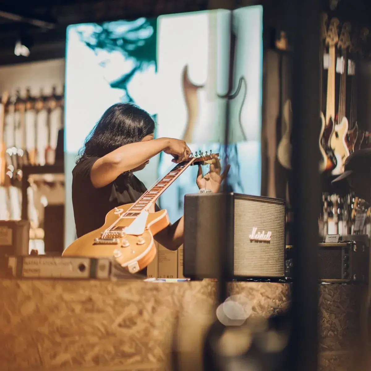 A Swee Lee technician adjusting a guitar